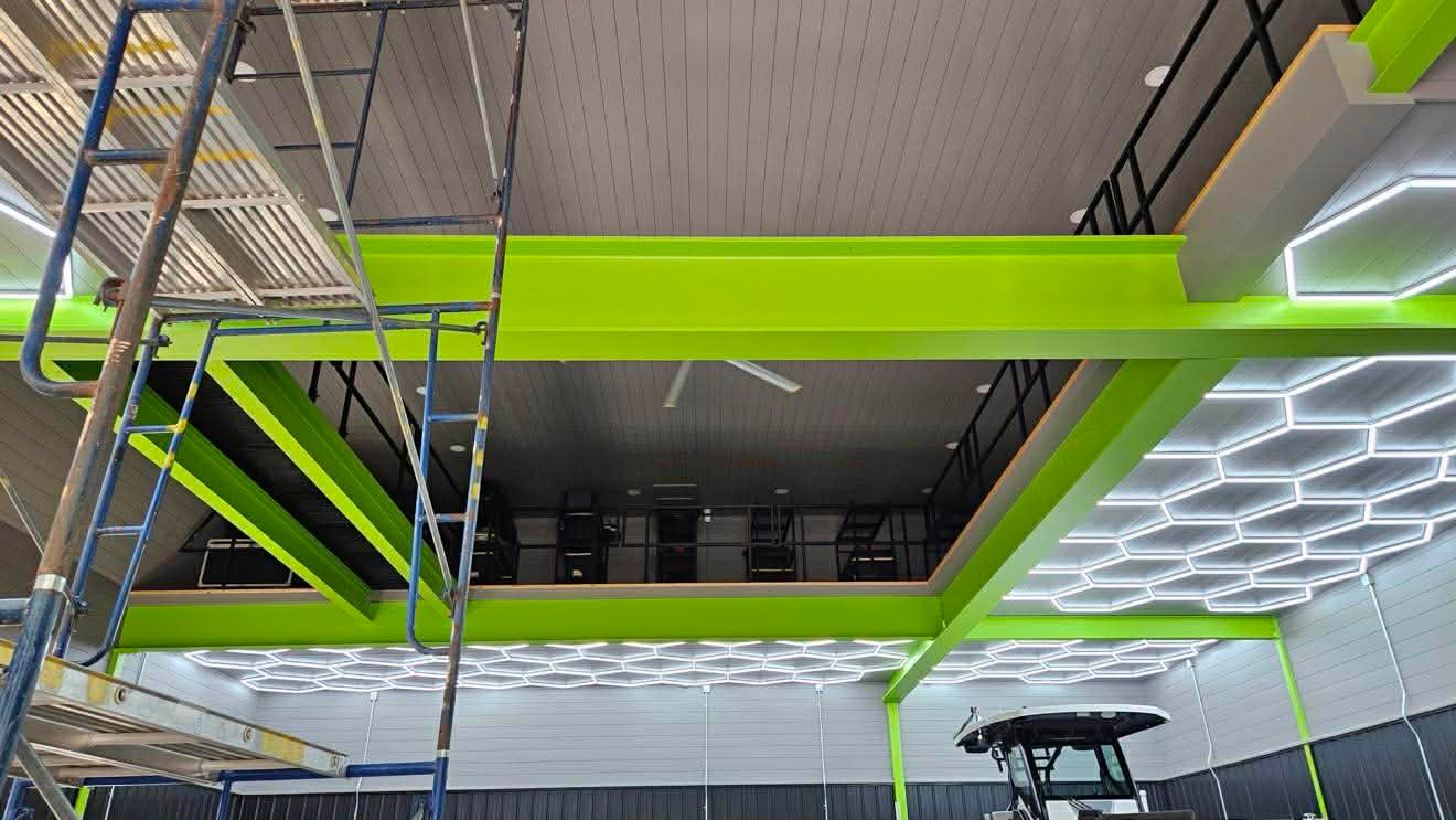 Commercial space with bright green I-beams + LED hexagon ceiling